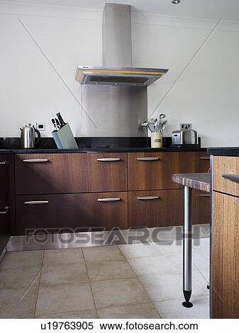 Limestone flooring in modern kitchen with dark brown fitted units View Large Photo Image Stock Photography - Limestone flooring in modern kitchen with dark brown fitted units. Fotosearch