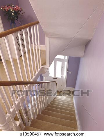 Stock Photo - Looking down staircase with cream carpet to pale mauve hall. Fotosearch