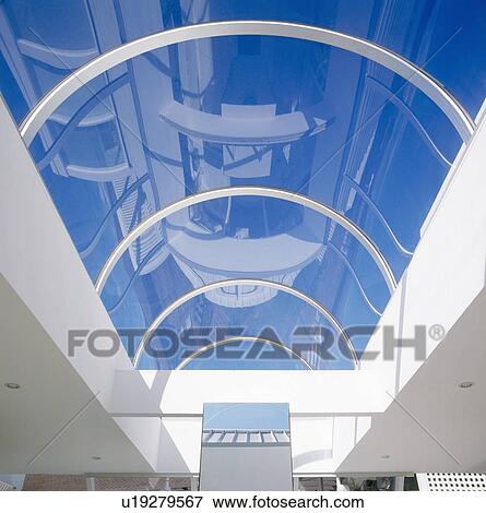 Looking up at blue sky through glass ceiling View Large Photo Image Stock Photo - Looking up at blue sky through glass ceiling. Fotosearch