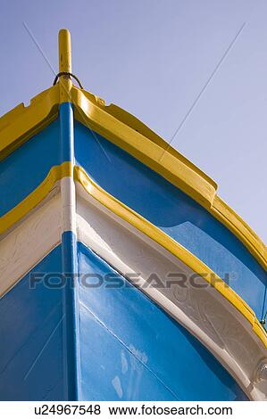 Stock Photo - Luzzu fishing boat moored in Saint Julian’s Harbour, Spinola Bay, Saint Julian’s, Malta. Fotosearch