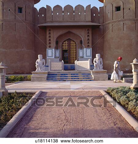 Stock Photo - Man in Rajastani dress on terrace below entrance door in the courtyard of the Rajasvilas hotel near Jaipur. Fotosearch