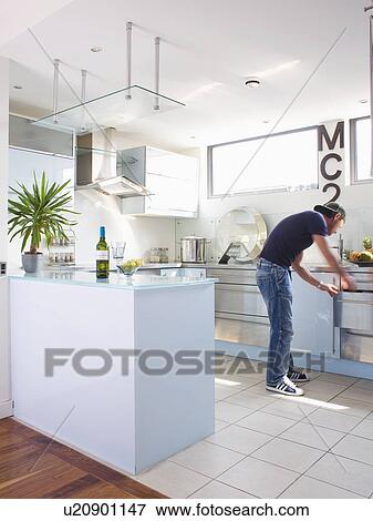 Man opening drawer in modern kitchen View Large Photo Image Stock Photo - Man opening drawer in modern kitchen. Fotosearch