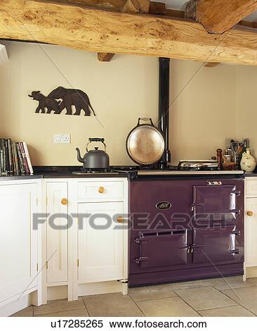 Stock Photography - Mauve Aga oven in cottage kitchen with large ceiling beams. Fotosearch