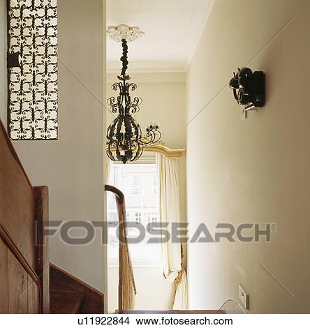 Picture - Metal chandelier above cream stairs on cream staircase. Fotosearch