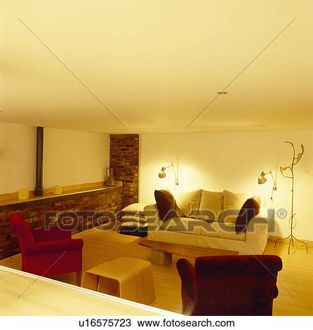 Stock Image - Metal floor lamps on either side of comfortable cream sofa in modern living room. Fotosearch