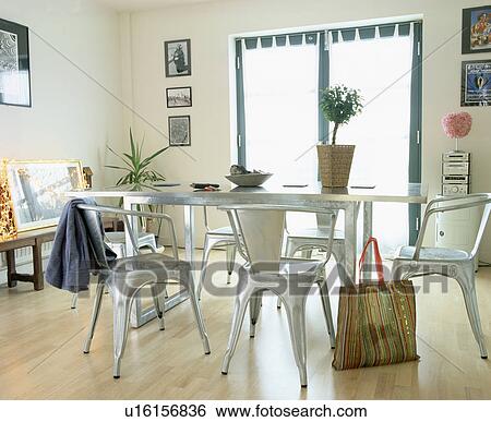Stock Photograph - Metal table and chairs in modern dining room. Fotosearch
