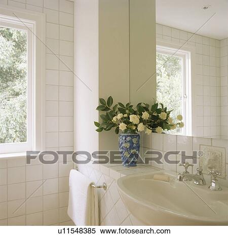 Mirror above basin in modern white tiled bathroom View Large Photo Image Stock Photography - Mirror above basin in modern white tiled bathroom. Fotosearch