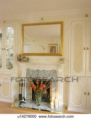 Stock Image - Mirror above fireplace in bedroom. Fotosearch