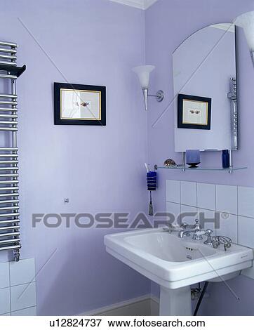 Mirror on wall above white pedestal basin in small mauve bathroom View Large Photo Image Stock Photo - Mirror on wall above white pedestal basin in small mauve bathroom. Fotosearch