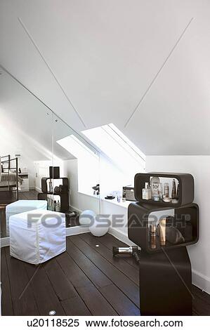 Stock Photography - Mirrored wall in white attic bedroom with black wooden flooring. Fotosearch