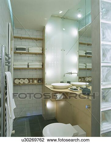 Stock Image - Modern bathroom with wall shelves andrecessed lighting. Fotosearch