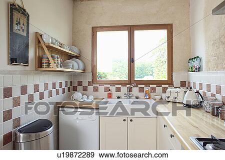 Modern kitchen in stone building with neutral coloured materials and beamed ceiling. View Large Photo Image Stock Photo - Modern kitchen in stone building with neutral coloured materials and beamed ceiling.. Fotosearch