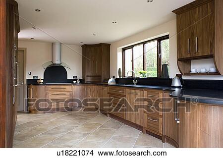 Picture - Modern kitchen with fitted walnut units and limestone tiled floor. Fotosearch