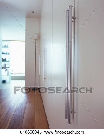 Modern landing with fitted white storage cupboard with steel handles View Large Photo Image Stock Photography - Modern landing with fitted white storage cupboard with steel handles . Fotosearch