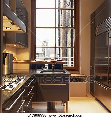 Stock Photo - Modern townhouse kitchen with steel handles on granite-topped units. Fotosearch