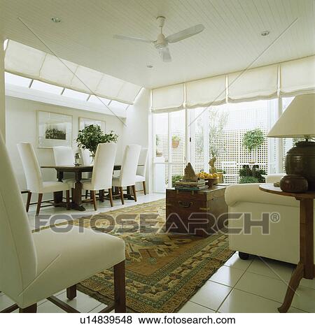 Modern white dining room extension with white upholstered chairs and oriental rug View Large Photo Image Stock Photo - Modern white dining room extension with white upholstered chairs and oriental rug. Fotosearch