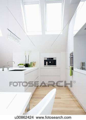 Picture - Modern white kitchen in apartment in loft conversion. Fotosearch