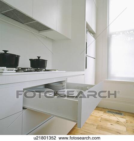 Modern white kitchen with drawer pulled out to reveal white plates View Large Photo Image Stock Image - Modern white kitchen with drawer pulled out to reveal white plates. Fotosearch