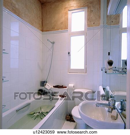Modern white tiled bathroom with unplastered wall View Large Photo Image Stock Photo - Modern white tiled bathroom with unplastered wall . Fotosearch