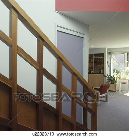Stock Image - Modern wooden banisters in modern white hall. Fotosearch