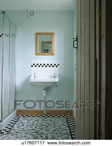 Stock Photo - Mosaic tiled floor and white basin below black+white tiled border in modern shower room. Fotosearch