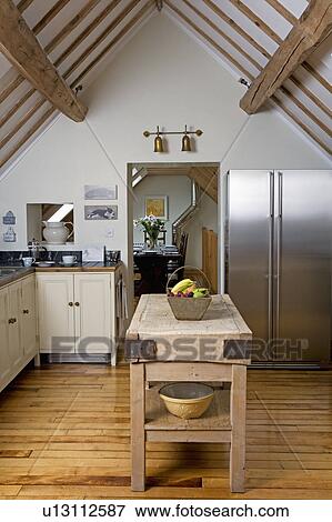 Old butchers block on wooden floorboards in modern country kitchen with American style fridge freezer and apex ceiling View Large Photo Image Stock Photo - Old butchers block on wooden floorboards in modern country kitchen with American style fridge freezer and apex ceiling. Fotosearch