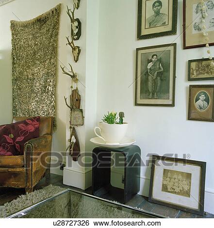 Old framed black & white African photographs on wall above outsize cup & saucer on small table in living room View Large Photo Image Stock Photograph - Old framed black & white African photographs on wall above outsize cup & saucer on small table in living room. Fotosearch