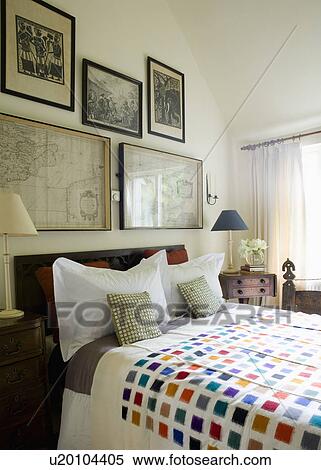 Old framed maps and black+white prints above bed with boldly patterned throw in modern white bedroom View Large Photo Image Stock Photography - Old framed maps and black+white prints above bed with boldly patterned throw in modern white bedroom. Fotosearch