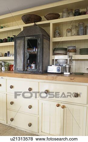 Old meat safe on worktop in country kitchen with cream fitted units below cream shelves View Large Photo Image Stock Photo - Old meat safe on worktop in country kitchen with cream fitted units below cream shelves. Fotosearch