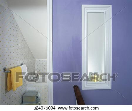 Picture - Opaque window in blue wall of small attic bathroom. Fotosearch