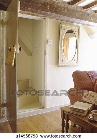 Open Door Below Large Beam To Staircase In Cottage Living Room Stock Image