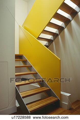 Stock Photo - Open-tread staircase with yellow walls. Fotosearch