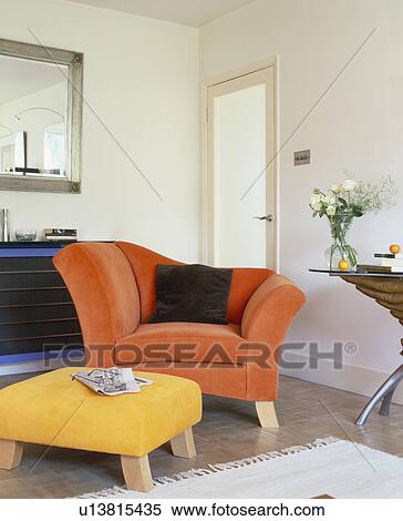 Orange armchair and upholstered yellow stool in modern white living room View Large Photo Image Stock Photography - Orange armchair and upholstered yellow stool in modern white living room. Fotosearch
