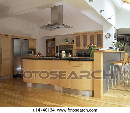 Picture - Pale wood curved fitted units in large modern kitchen extension with breakfast bar. Fotosearch