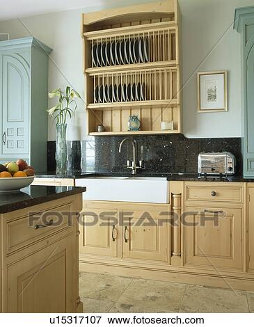Pale wood fitted units and plate rack in country kitchen View Large Photo Image Stock Photo - Pale wood fitted units and plate rack in country kitchen. Fotosearch