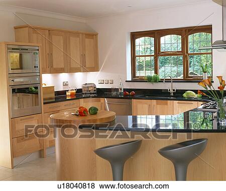 Stock Photo - Pale wood fitted units in modern kitchen. Fotosearch