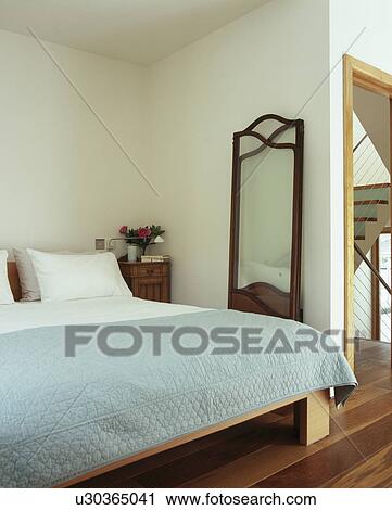 Pastel blue quilt and white pillows on bed in modern bedroom with long mirror View Large Photo Image Stock Image - Pastel blue quilt and white pillows on bed in modern bedroom with long mirror. Fotosearch
