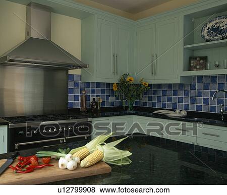 Stock Photo - Pastel turquoise fitted units in traditional country kitchen. Fotosearch