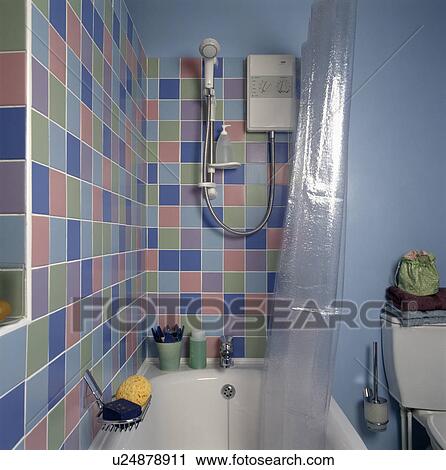 Pastel wall tiles above bath in blue economy-style bathroom View Large Photo Image Stock Image - Pastel wall tiles above bath in blue economy-style bathroom. Fotosearch