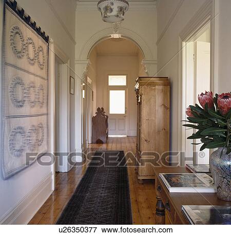 Patchwork quilt on wall of white hall with oriental carpet runner View Large Photo Image Stock Photo - Patchwork quilt on wall of white hall with oriental carpet runner. Fotosearch