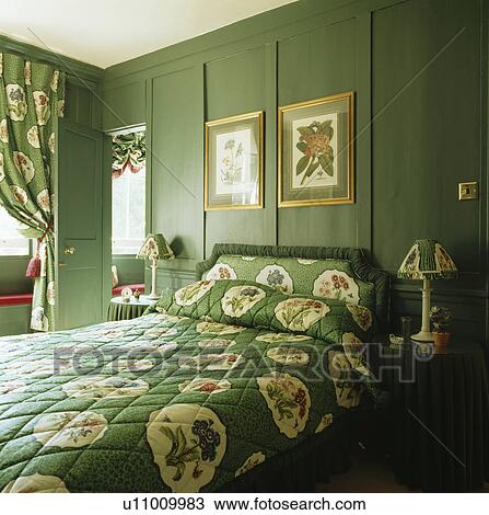 Stock Image - Patterned green bedlinen in panelled green bedroom. Fotosearch