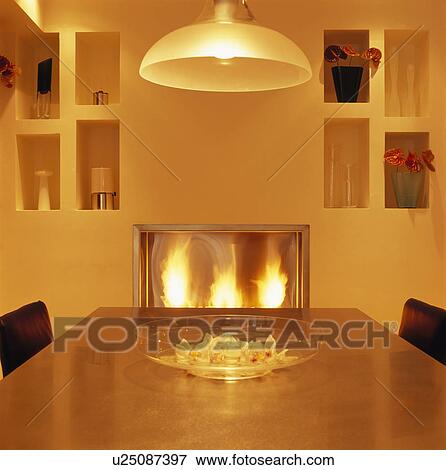 Stock Photo - Pendant light above table in modern yellow dining room. Fotosearch