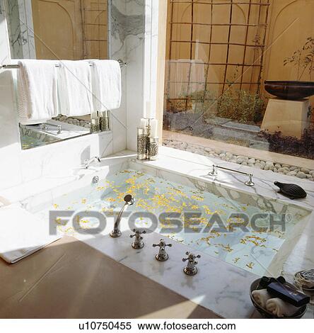 Petals floating in sunken marble bath in Indian bathroom View Large Photo Image Stock Photography - Petals floating in sunken marble bath in Indian bathroom. Fotosearch
