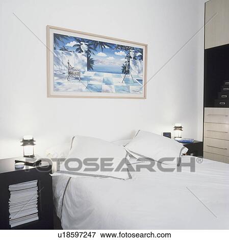 Stock Photo - Picture above bed in white bedroom. Fotosearch