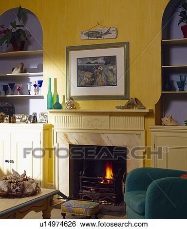 Picture above fireplace in yellow living room with blue alcoves View Large Photo Image Stock Photograph - Picture above fireplace in yellow living room with blue alcoves. Fotosearch