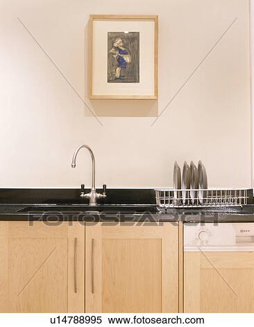 Stock Photography - Picture above sink in granite worktop in modern fitted kitchen. Fotosearch