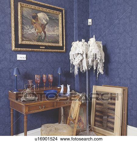 Picture on wall above antique desk in corner of dining room with blue wallpaper and melted candles on tall candleholder View Large Photo Image Picture - Picture on wall above antique desk in corner of dining room with blue wallpaper and melted candles on tall candleholder. Fotosearch