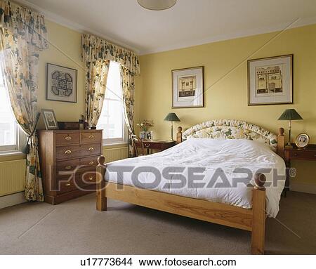 Pine bed in traditional pastel yellow bedroom View Large Photo Image Picture - Pine bed in traditional pastel yellow bedroom. Fotosearch