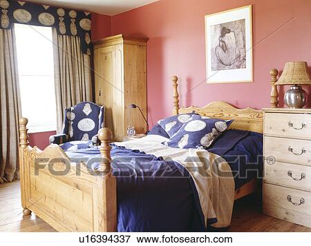 Pine bed with blue bedlinen in pink bedroom View Large Photo Image Stock Photo - Pine bed with blue bedlinen in pink bedroom. Fotosearch