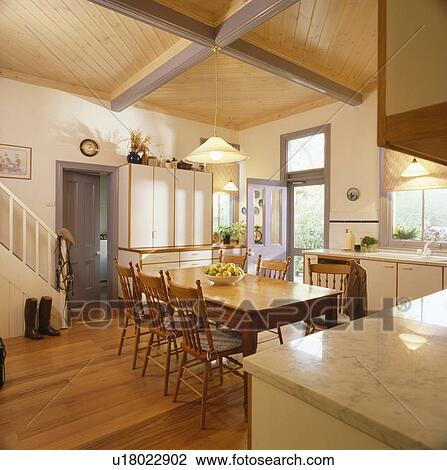 Pine table and chairs in country kitchen extension with blue doors View Large Photo Image Stock Image - Pine table and chairs in country kitchen extension with blue doors. Fotosearch